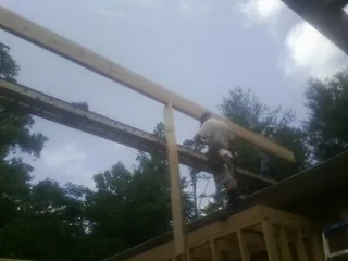 Carpenter setting a ridge beam over a new addition frame — Ice Dam Removal by Roofing Brothers in Seaside Heights