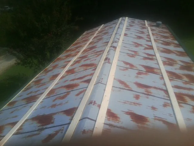 Rusted metal roof panels with new wood purlins before replacement — Storm Damage Roof Repair in Seaside Heights by Roofing Brothers