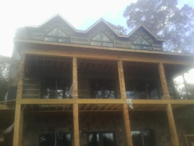Dormers and porch framing on a large log home under construction — Roof Coating work by our crew in Seaside Heights